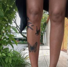 a woman's legs with butterfly tattoos on them