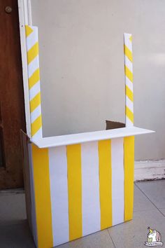 a yellow and white striped box with two candles sticking out of it's sides