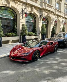 two red sports cars parked in front of a building