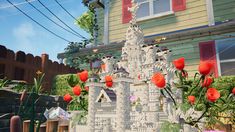 a castle made out of legos and flowers in front of a house with red shutters