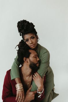 a man and woman hugging each other in front of a white background with the caption's name on it