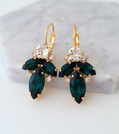 pair of green and white crystal earrings on marble slab