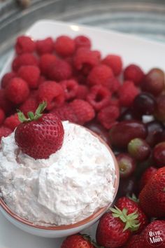 strawberries, grapes and whipped cream on a plate