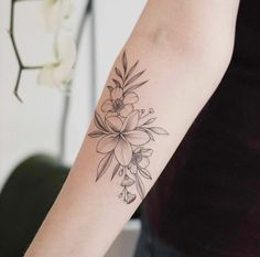 a woman's arm with a flower tattoo on the left side of her arm