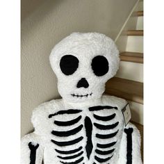 a stuffed skeleton sitting on top of a stair case