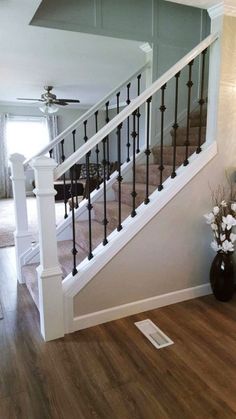 a living room filled with furniture and a stair case next to a wooden flooring