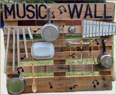 a wooden pallet with various kitchen utensils and pans hanging on it