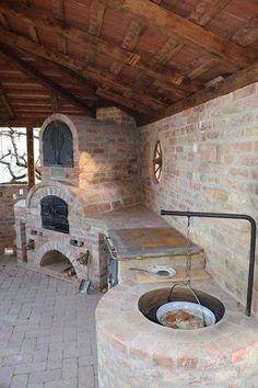 an outdoor kitchen with brick oven and grill