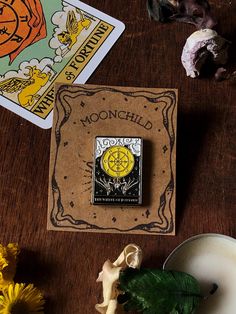 a pin sitting on top of a wooden table next to some flowers and other items