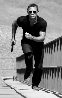 black and white photograph of a man running on a bridge with sunglasses on his face