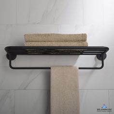 a towel rack with two towels hanging on it's side and a white wall behind it