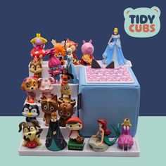 there are many figurines on display in this case, including the little mermaid and other disney characters