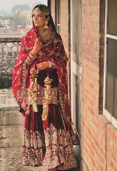 a woman in a red and gold bridal outfit