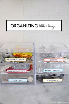 two clear plastic drawers with labels and magnets in them on a marble countertop