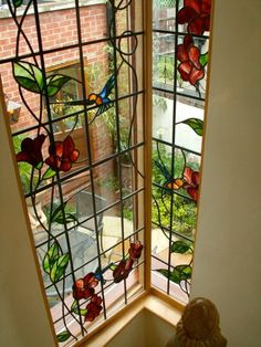 two stained glass windows with flowers on them in the corner of a room next to a window