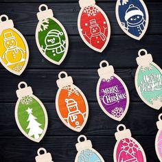 colorful christmas ornaments are displayed on a wooden surface with the words merry christmas written in different colors