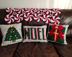 three christmas pillows are sitting on a couch