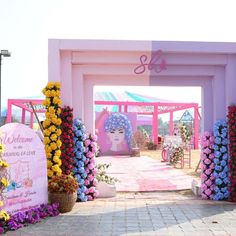 the entrance to an event with flowers and decorations on display for people to see in it