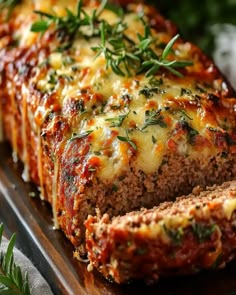 sliced meatloaf with cheese and herbs on top