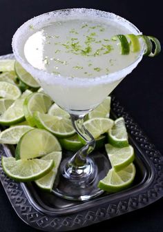 a margarita cocktail with limes on the rim