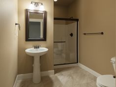 a bathroom with a toilet, sink and shower stall in it's corner area