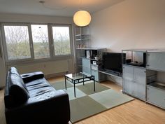 a living room with a couch, television and entertainment center