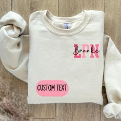 a white sweatshirt with pink letters and the word broke on it, next to a pile of fur