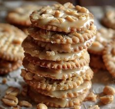 a stack of cookies sitting on top of a table covered in frosting and nuts