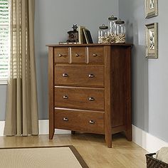 a wooden dresser sitting in a living room next to a window