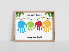 a framed poster with the words merry and bright hanging on a string in front of a white wall