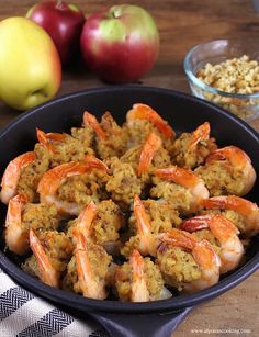 cooked shrimp and rice in a skillet next to apples