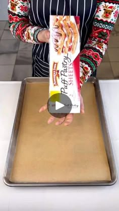 a woman holding a box of krispy kreme doughnuts on top of a pan