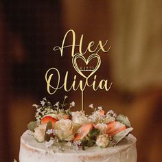 a wedding cake with the name alex and julia on top is decorated with fresh flowers