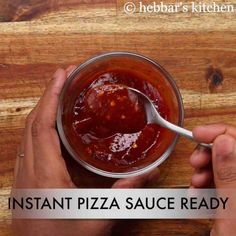 someone holding a spoon over a bowl of pizza sauce on a wooden table with the words instant pizza sauce ready