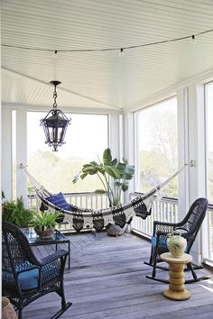 a porch with hammock chairs and potted plants