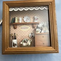 there is a miniature shelf with many items on it in the frame and some keys