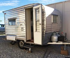 an old trailer is parked in the gravel