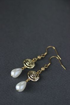 Beautiful earrings with white pearl coated glass drop beads (13x9 mm), gold plated (brass base) oval charms and gold plated stainless steel earring hooks. Earring hooks are from nickel free and lead free metal. Wonderful unique jewelry for you or an a great gift! *The total lenght of earrings is about 58 mm including earring hooks. Other earrings of my shop you can see here: https://www.etsy.com/shop/NaTavelli?section_id=13757927 Thanks for visit. Gold Beaded Dangle Earrings With French Hook, Vintage Gold Teardrop Beaded Earrings, Bohemian Brass Pearl Drop Earrings, Gold Bohemian Beaded Earrings With Pearl Drop, Brass Pearl Drop Dangle Chandelier Earrings, Brass Dangle Chandelier Earrings With Pearl Drop, Brass Chandelier Earrings With Pearl Drop, Gold Bohemian Pearl Earrings With Dangling Beads, Bohemian Gold Pearl Earrings With Dangling Beads