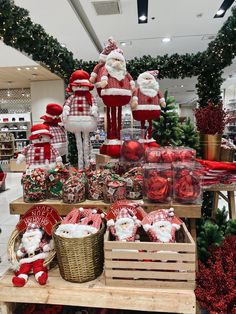 christmas decorations are on display in a store with santas and other holiday items behind them