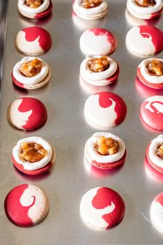 several red and white desserts on a metal tray