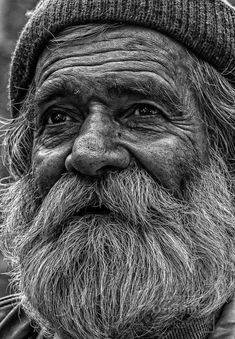 black and white photograph of an old man with long beard wearing a beanie hat