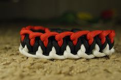 an orange and black bracelet on the ground