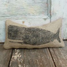 a burlap pillow with a fish on it