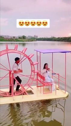 a man and woman are riding on a boat in the water with an amusement wheel