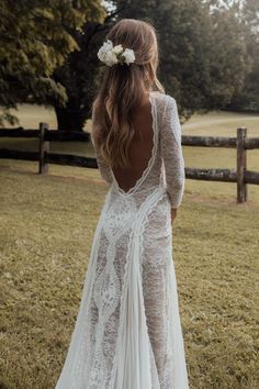 the back of a woman's wedding dress in a field