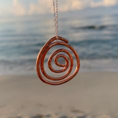 A rustic raw copper Celtic spiral pendant, hand forged and lightly hammered, hanging from an 18'' / 45 cm sterling silver chain with a sterling silver bail (other chain lengths available - see below). The 3 cm pendant has been highly polished to give a lovely shiny finish.  This unique pendant is perfect for any occasion and would make a lovely birthday gift for someone who loves copper and boho style jewellery. Also an ideal 7th wedding anniversary gift. This pendant is great for any occasion - Celtic Spiral, Wave Jewelry, 7th Wedding Anniversary, Spiral Pendant, 7th Anniversary Gifts, 7th Anniversary, Boho Style Jewelry, Anniversary Gifts For Wife, Unique Pendant