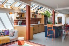 an open kitchen and living room with skylights