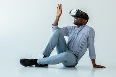 a man sitting on the ground with his legs crossed and wearing a virtual reality headset