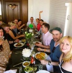 a group of people sitting at a table with plates of food in front of them