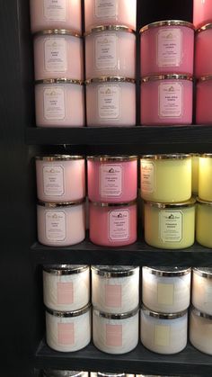 candles are lined up on shelves in a store